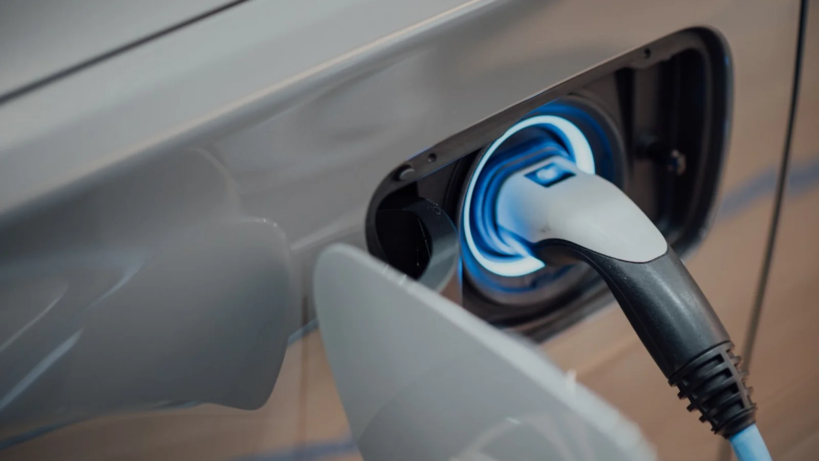 Carro eletrico carregando — seguro com cobertura de bateria, cabo e wallbox